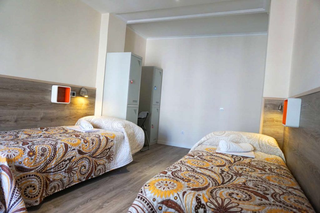 Cama en habitacion cuadruple con baño compartido