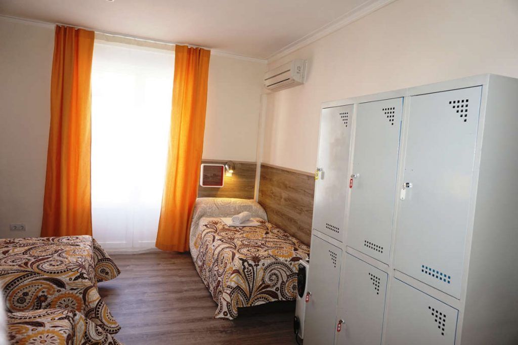 Cama en habitacion cuadruple con baño compartido