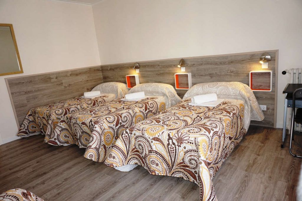 Cama en habitacion cuadruple con baño compartido