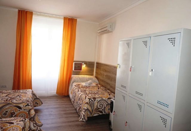 Cama en habitacion cuadruple con baño compartido