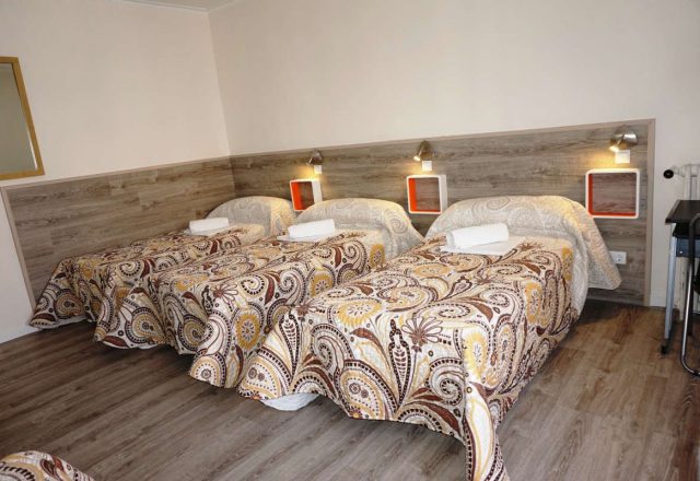 Cama en habitacion cuadruple con baño compartido